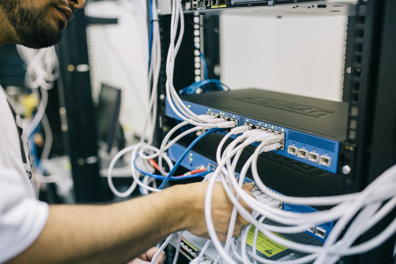 An engineer working among network cables in a server rack