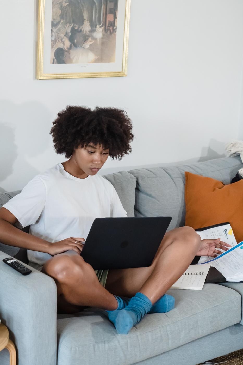 A person with curly hair working on a laptop