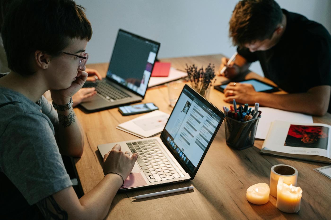 Two people studying together at a table in the evening
