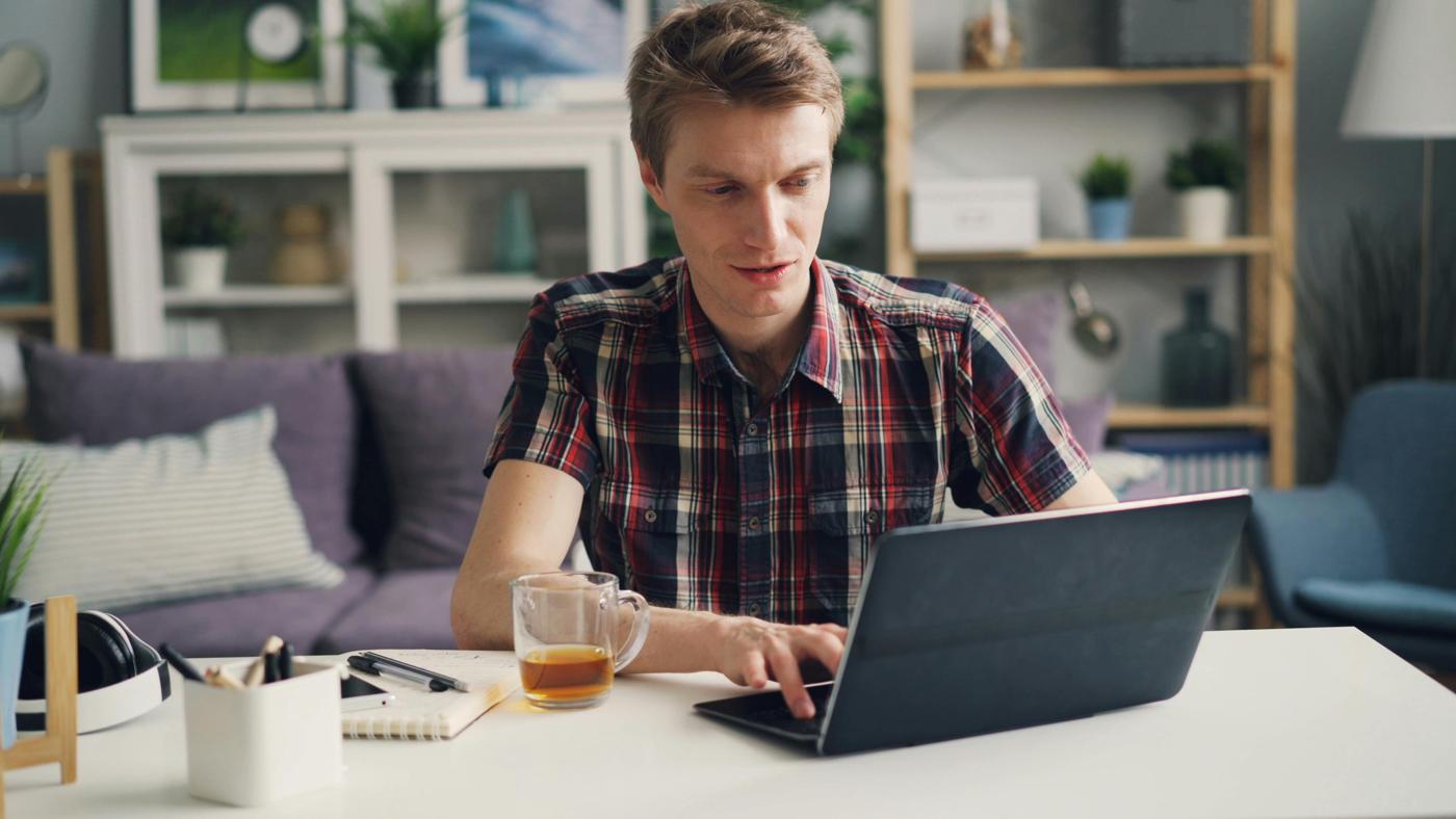 A man studying on his laptop in his living room