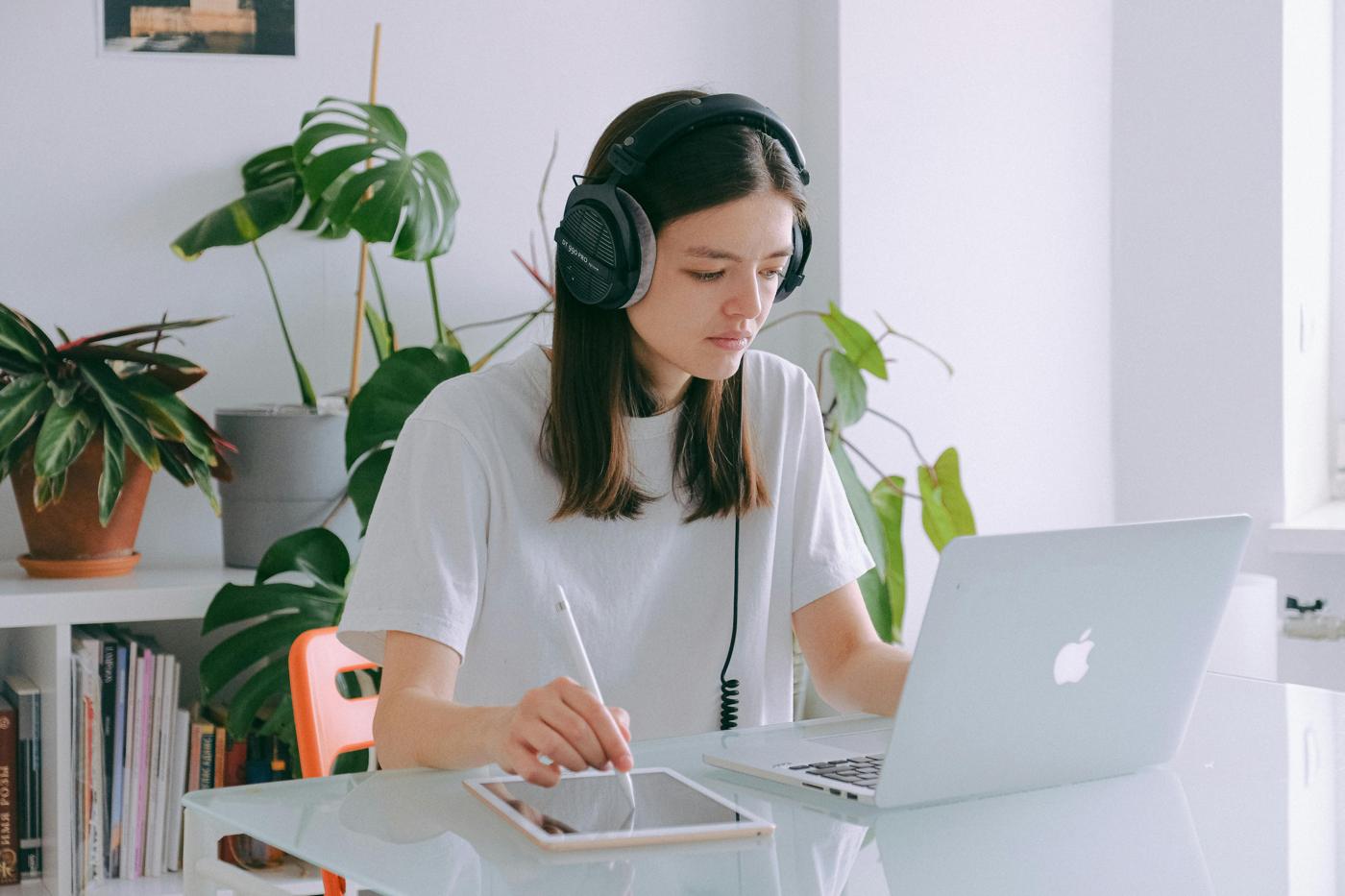 A person with headphones following an online class at home